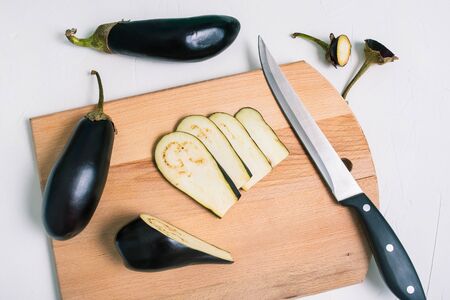 Sliced eggplant on a wooden board. Cooking fried eggplant. Raw vegetables for healthy and wholesome...