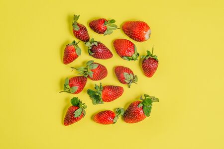Fresh strawberries on a colored background. Group of large red berries on a yellow backgroundの写真素材