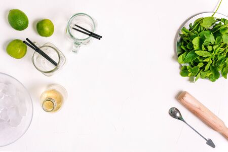 Mojito cooking process with copy space. Ingredients for a summer cocktail. Fresh mint, glass goblets, lime, rum and ice.の写真素材