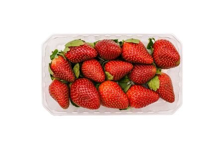 Plastic container with strawberries isolated on a white background. Fresh and ripe summer berries in the package. Top view, flat layの写真素材