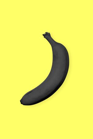 Black banana on a yellow background. Surrealistic Minimalist Art.の写真素材