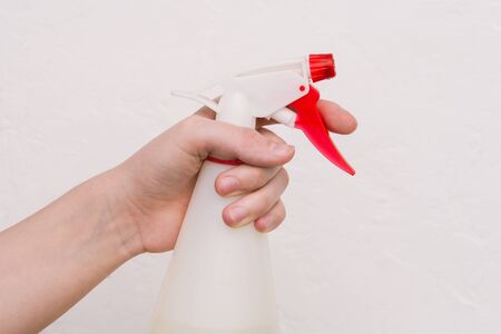 Washing and cleaning supplies on a white background. A hand in a yellow glove holds a dispenser on a white backgroundの写真素材