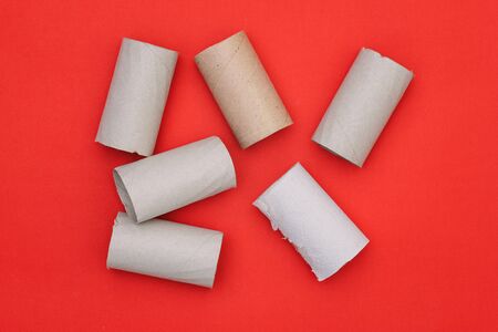 Round cardboard tubes on a red background. Toilet paper. Rubbish waste for processing.の写真素材
