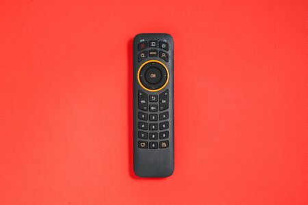 Remote control with buttons on a red background. Smart TV concept. Home entertainmentの写真素材