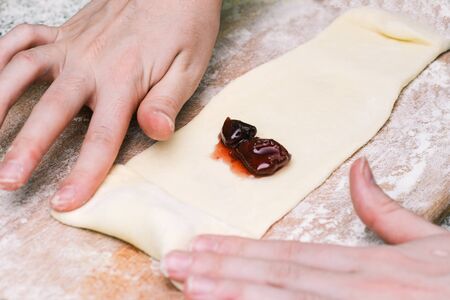 Dough and jam on a wooden board. Making baked pastryの写真素材