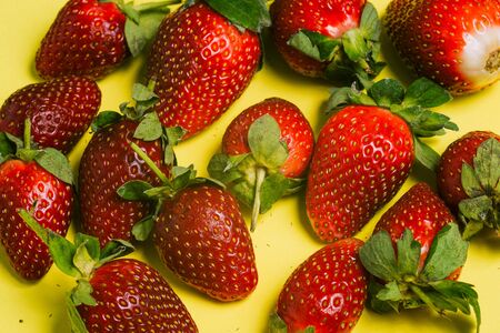 Strawberries on a yellow background. Fresh sweet fruit close-upの写真素材