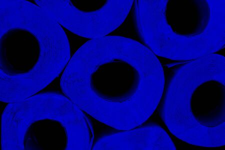 Blue rolls of toilet paper on a black background. Personal hygiene concept