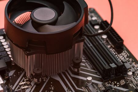 Cooler with a fan is installed on a computer motherboard. The cooling system of the processor on the computerの写真素材