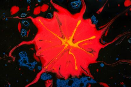 Colorful pattern of natural colors. Red spot with streaks on a black background. Mixed colors. An abstract texture.の写真素材