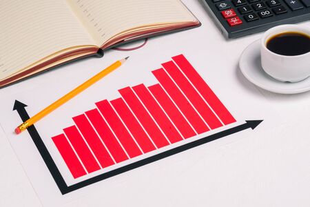 Office Desk with a chart, a calculator, open the diary and Cup of coffee. Company income, investments, and Finance. Business concept.の写真素材