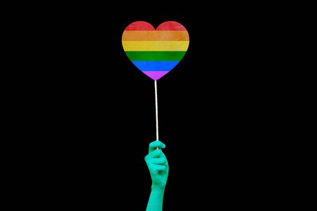 LGBT pride month. The girls hand holds a rainbow heart on a black background. Symbol of the LGBT community. Gay and lesbian love. Human rights and tolerance.の写真素材