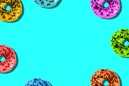Donuts are colored on a bright background with a copy of the space. Unhealthy diet. Minimum summer template.の写真素材