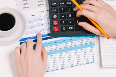 Businessman works with documents. Financial documents with charts, figures, and money. Calculator and hands. Marketing research, financial analysis of the company and analytical reportの写真素材