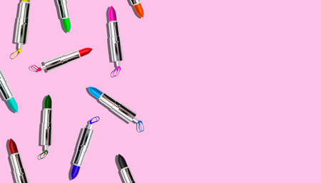 Set of colored lipstick on a pink background. Cosmetic product. Minimal style. Top view with a copy of the space.の写真素材
