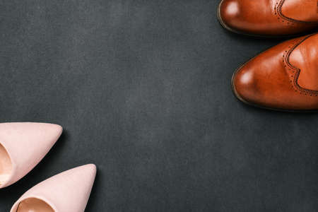 Mens and womens shoes on a black background with a copy of the space. Sale and delivery of shoes from the store, womens and mens fashionの写真素材