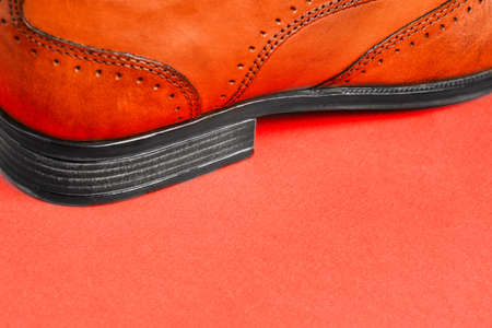 Mens shoes close - up on a red background with a copy of the space. Mens fashion. Sale and delivery of shoes from the storeの写真素材