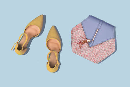 Golden womens shoes and a fashionable bag on a colored background. The minimum concept of fashion and shopping. Womens blog.の写真素材