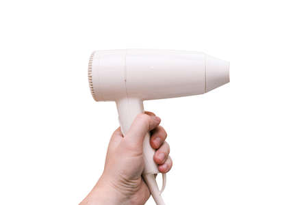Hair dryer isolated on a white background. White hair dryer in the hand of a woman for drying hair. Barbers tool for working in a beauty salonの写真素材