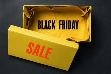 Opened yellow shoebox on a dark background with the text Black Friday Saleの写真素材