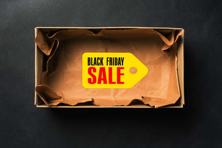 Black Friday sale. Open empty box with a tag on a dark background.の写真素材