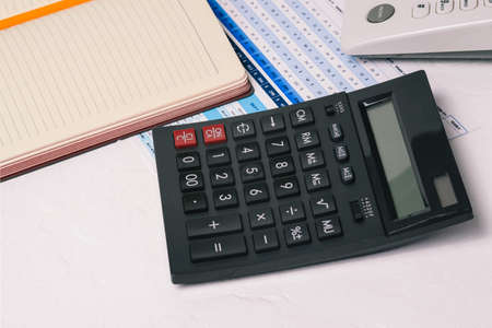 Accountants desk. Close-up calculator, notepad, telephone and financial and economic documents of the company. Report preparation, data analysis. Finance and economicsの写真素材