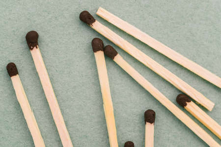 Whole matches close-up on a green background. Top view, flat lay