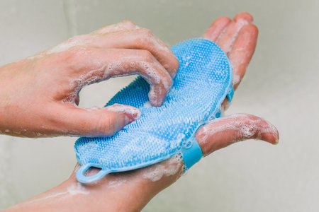 Washing hands with soap. A woman cleans her hands from viruses with a blue brush. Coronavirus prevention, hygiene. Protection from infectionの写真素材