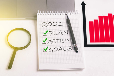 Plan and goals for 2021. Action text in notepad. Worker office desk. Business motivation, ideas for inspirationの写真素材
