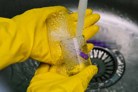 The scientist is conducting research. Hands in yellow protective gloves hold the flask. Chemical experiment in the laboratory. Doctor in the laboratoryの写真素材