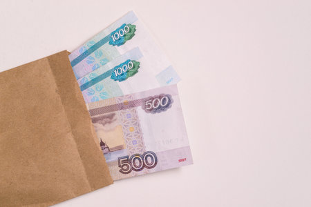 Stack of cash Russian money and an envelope on a white background. Avoiding company taxes.の写真素材