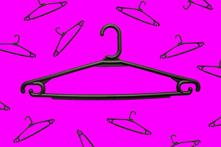 Large and small plastic hangers on a bright background. Black clothes holders. Household, wardrobe and sale of goods. Creative idea, minimal styleの写真素材
