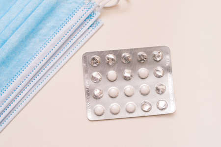Packaging with pills and disposable medical masks on a white background.の写真素材
