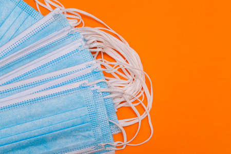 A lot of medical masks on a colored background with copy space. Medical protective mask. Quarantine during a pandemic. Coronavirus protection. Top view, flat layの写真素材