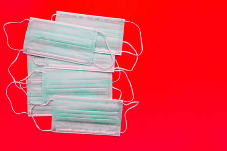 Medical masks on a red background with copy space. Top view, flat layの写真素材