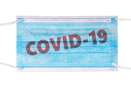 Medical mask isolated on white background and text with inscription COVID-19. Blue mask. Top view, flat layの写真素材