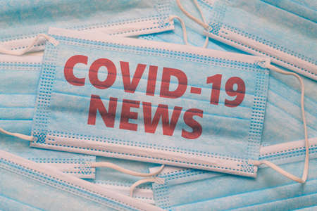Medical face mask and text with news headline Covid-19.の写真素材