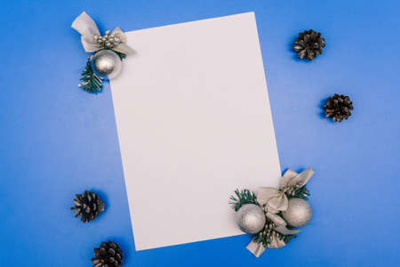 Christmas background with blank paper for text, Christmas decorations and pine cones. New Year composition, templateの写真素材