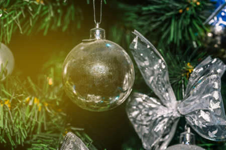 Christmas background. Close-up silvery toy weighs on a spruce branch. Festive atmosphereの写真素材