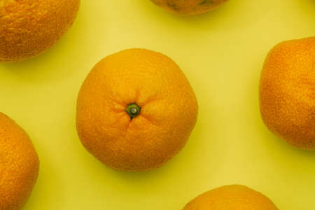 Tangerines close-up on a colored background. Healthy food with vitamins. Ripe orange fruit. View from aboveの写真素材