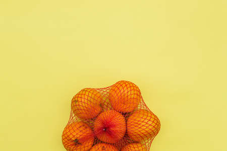Fresh tangerines on a yellow background with copy space. Top view, flat lay. Healthy food with vitaminsの写真素材