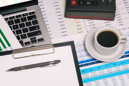 Accounting in the company. Workplace with a financial chart, pen, computer, calculator and a cup of coffee. Audit, analytics and banking. Business conceptの写真素材