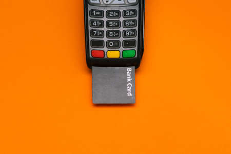 Electronic device for accepting payment cards. Modern POS payment terminal and bank card with copy space. Top view, flat layの写真素材