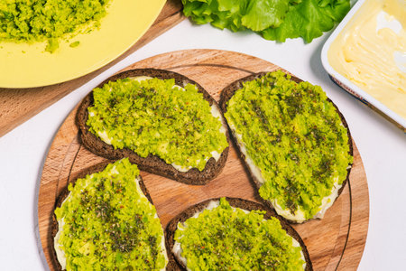 Vegetarian toast with avocado. Colorful vegan snacks. Top view of sandwiches with avocado and salad on a wooden surface. Healthy homemade creamy toastの写真素材