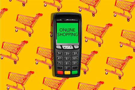 E-commerce concept. Payment terminal and shopping cart with the inscription Shopping online.