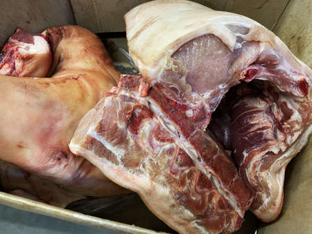 Sliced pieces of meat. Parts of a killed animal in a box. Selling pork for food in the market.の写真素材