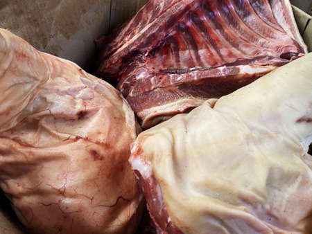 Pork meat and bones in a box. Fresh animal meat for sale. Large pieces of meat in the storeの写真素材