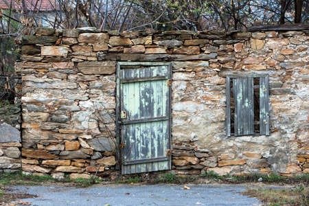 Broken door, window and a stone wall.の写真素材