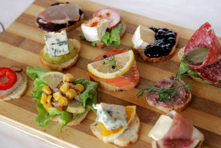 Variety of fresh canapes on a cutting boardの写真素材