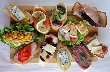 Variety of fresh canapes on a cutting boardの写真素材