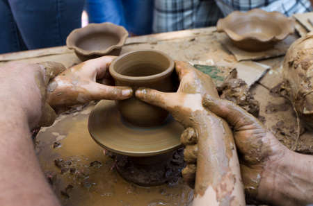 Potter makes a jug out of clay.